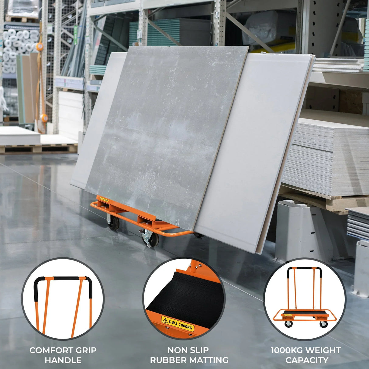 Dry wall cart with orange frame, non-slip rubber matting, and comfort grip handle, holding large plasterboards in a warehouse setting