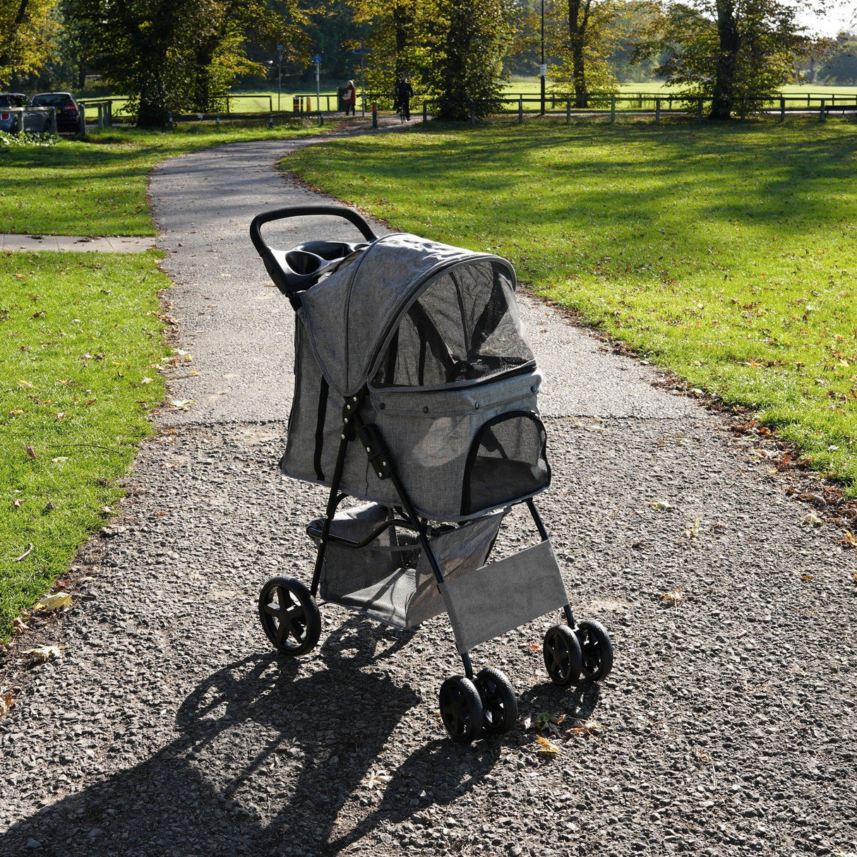 Woven grey pet stroller with rain cover, featuring a spacious mesh canopy, sturdy wheels, and a comfortable seat for pets