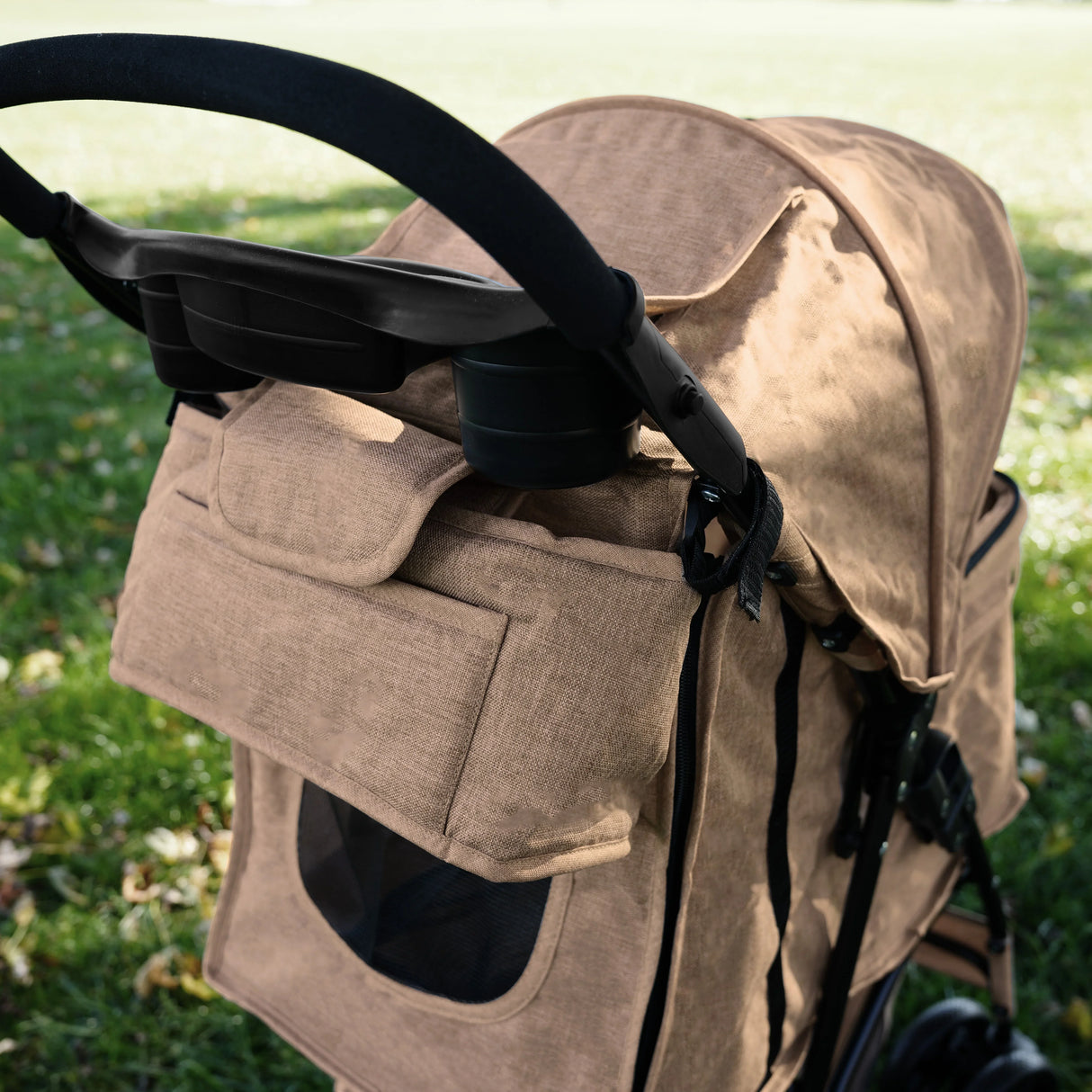 Woven beige pet stroller caddy bag with spacious pockets, mesh window, and sturdy handle, perfect for outdoor adventures