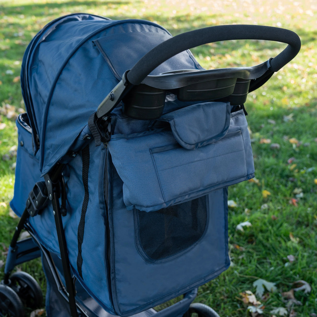 Navy blue pet stroller featuring a rain cover, caddy bag, and mesh window, designed for comfort and convenience on outdoor walks