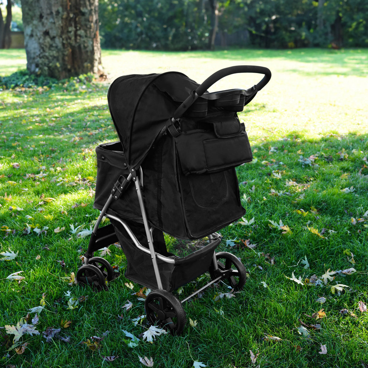 Black pet stroller caddy bag with multiple storage pockets, sturdy frame, and smooth wheels, set on grass with autumn leaves