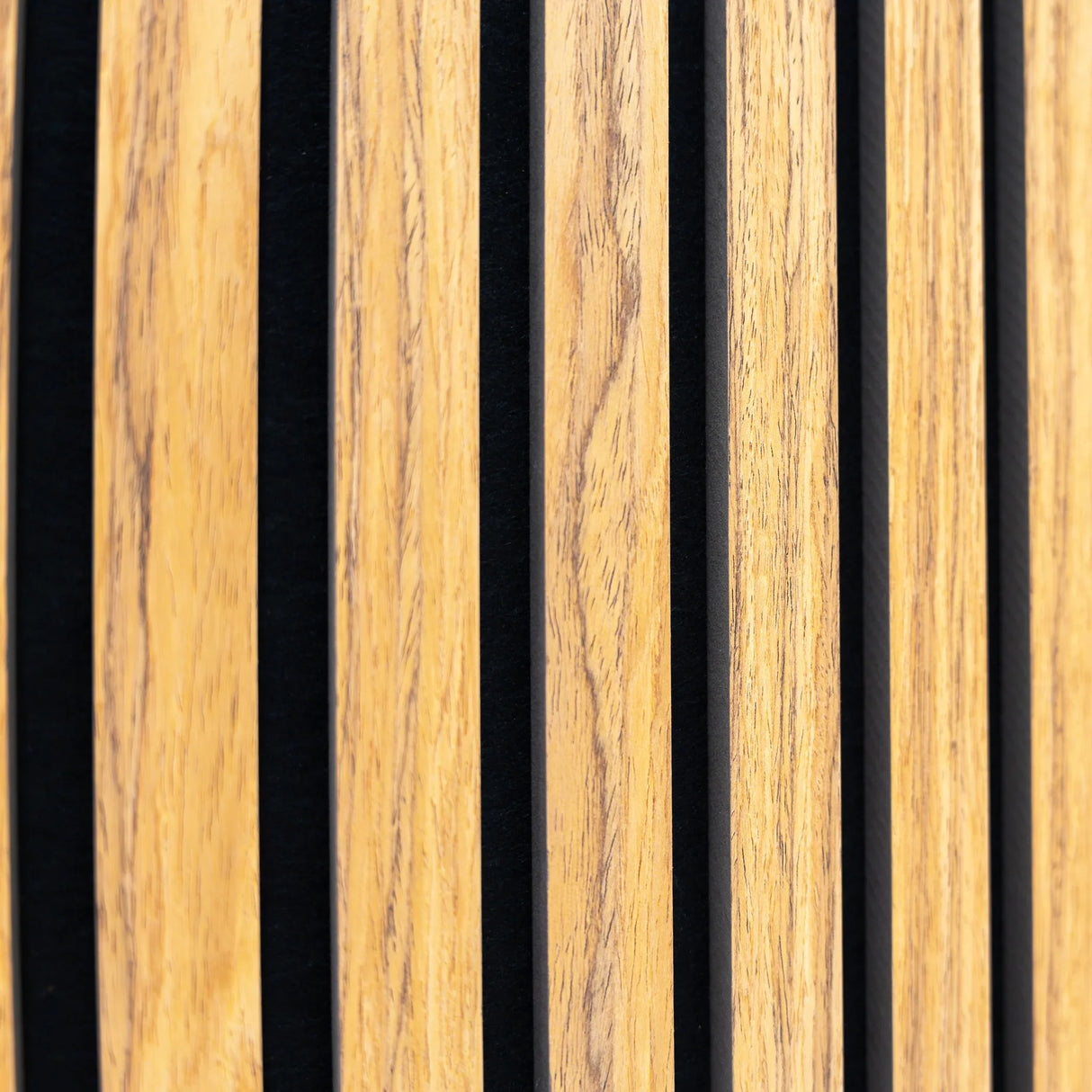 Acoustic slat wall panels in oak finish with black felt backing, showcasing vertical slats for sound absorption and modern decor