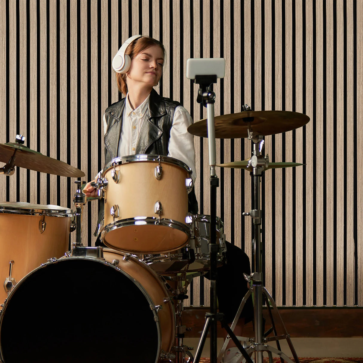 Light walnut acoustic slat wall panels enhance sound quality, featuring vertical slats and a warm wood finish, ideal for studios