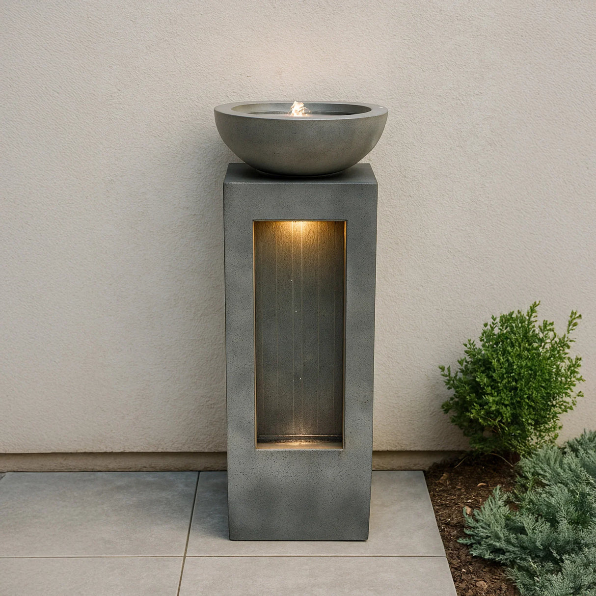 Serenity Falls electric water feature with a sleek gray concrete design, bowl-shaped top, and illuminated water stream for outdoor tranquility