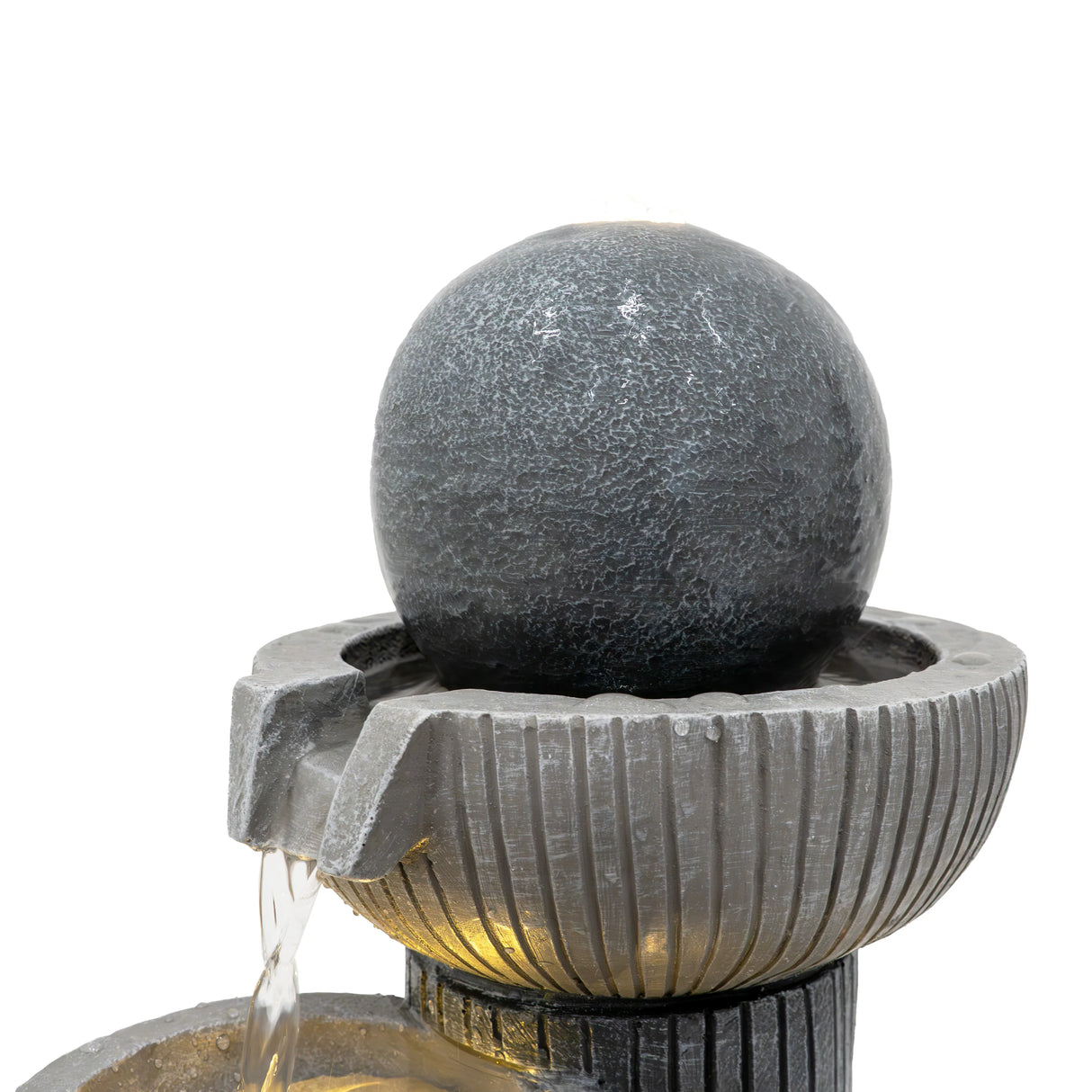 Electric water feature with a textured dark gray sphere atop a ribbed basin, gently cascading water for a calming ambiance