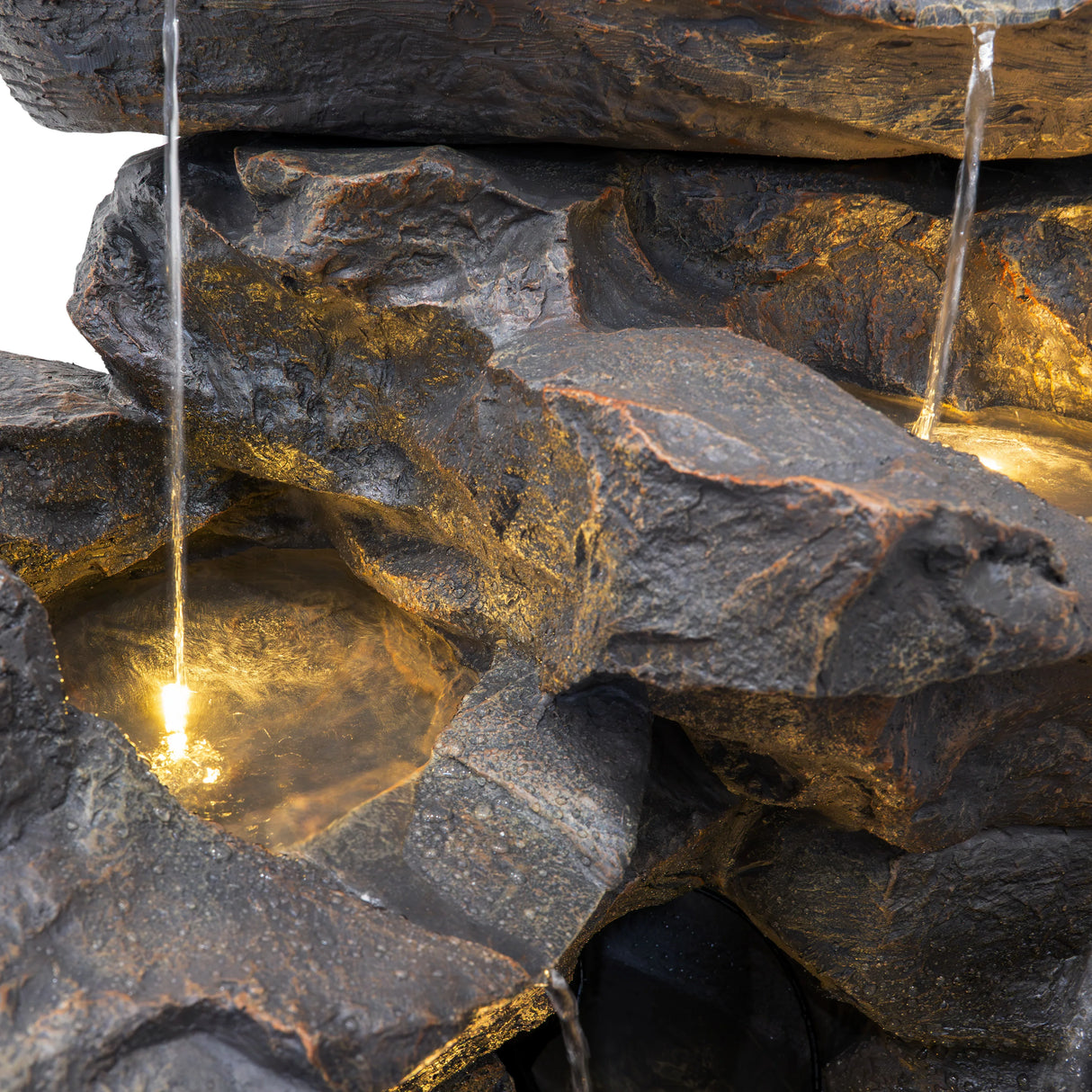 Rustic Rapids electric water feature with textured dark stone, cascading water, and warm glowing lights illuminating the design