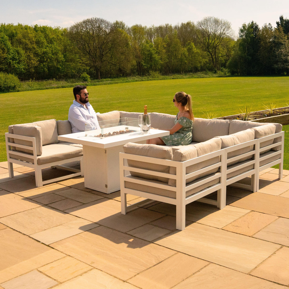Modular white garden furniture set with plush beige cushions and a central fire pit, perfect for outdoor relaxation and gatherings