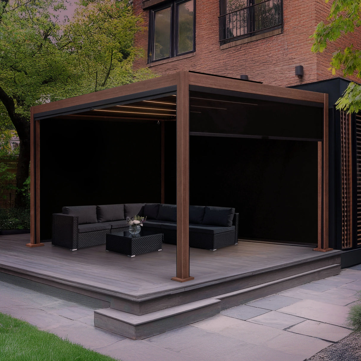 Wood effect aluminium pergola with blinds and LED lights, featuring a modern design, black seating, and a stylish outdoor setting