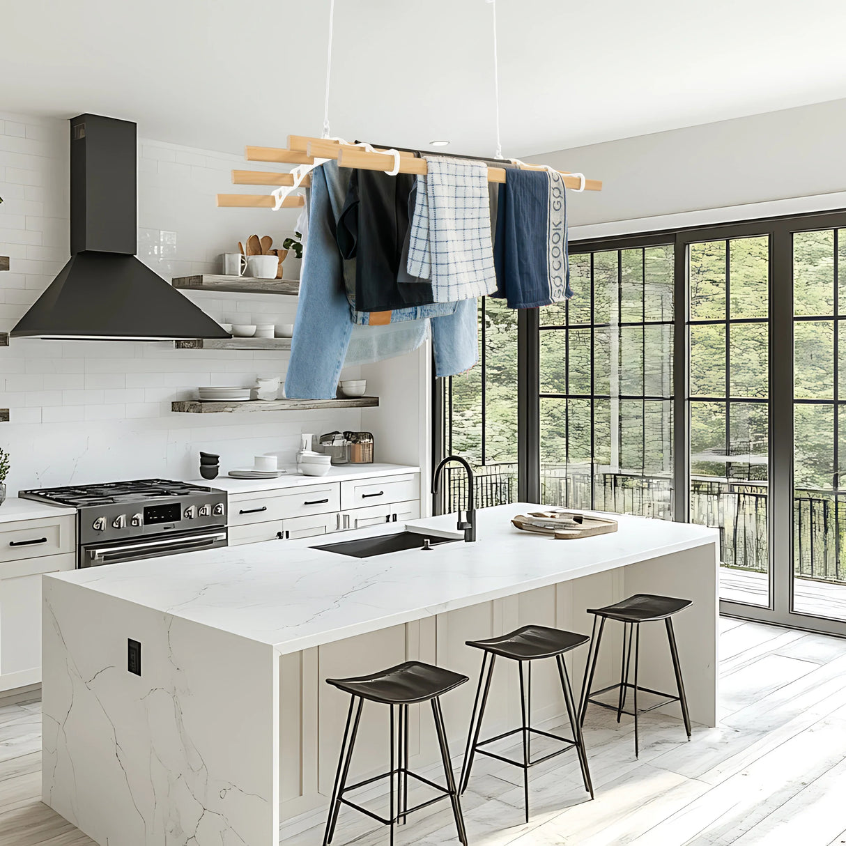 Ceiling pulley clothing airer in white, suspended above a modern kitchen island, holding shirts and jeans, with large windows in the background