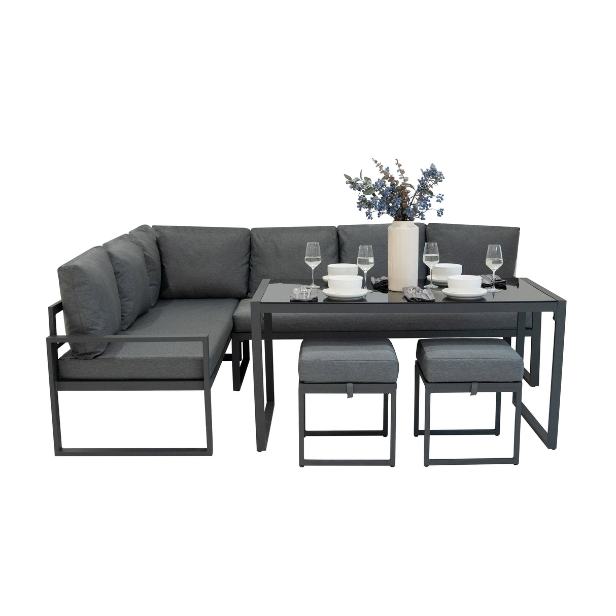 Anthracite grey aluminium corner sofa set with plush cushions, stylish dining table, and decorative vase with flowers