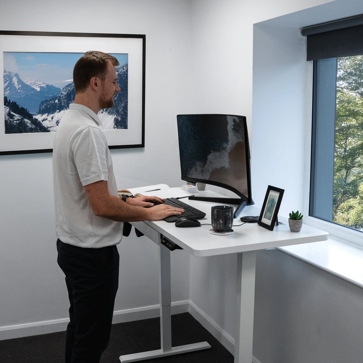 Electric standing desk with drawer, sleek white finish, ergonomic design, adjustable height, modern workspace with scenic view