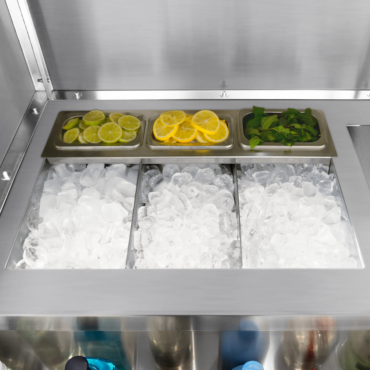 Mobile cocktail bar station featuring stainless steel ice compartments filled with crushed ice, fresh lemon, lime slices, and mint leaves