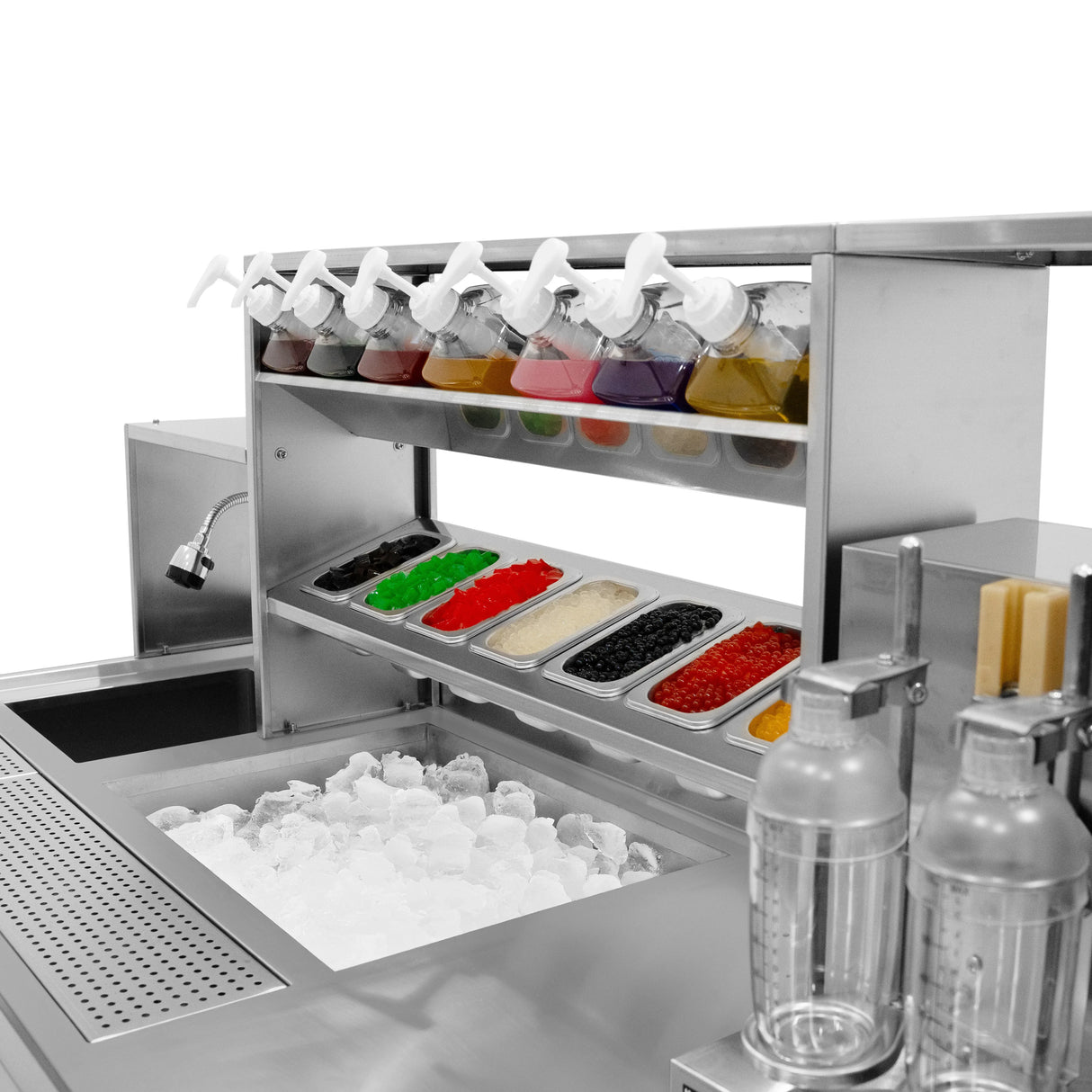 Stainless steel bubble tea workstation with colorful syrup dispensers, ice bin, and various toppings in clear containers