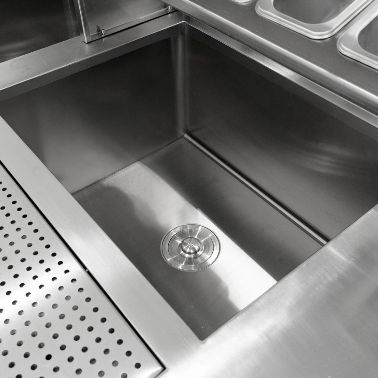 Stainless steel sink with polished finish, featuring a central drain and smooth edges, designed for bubble tea preparation