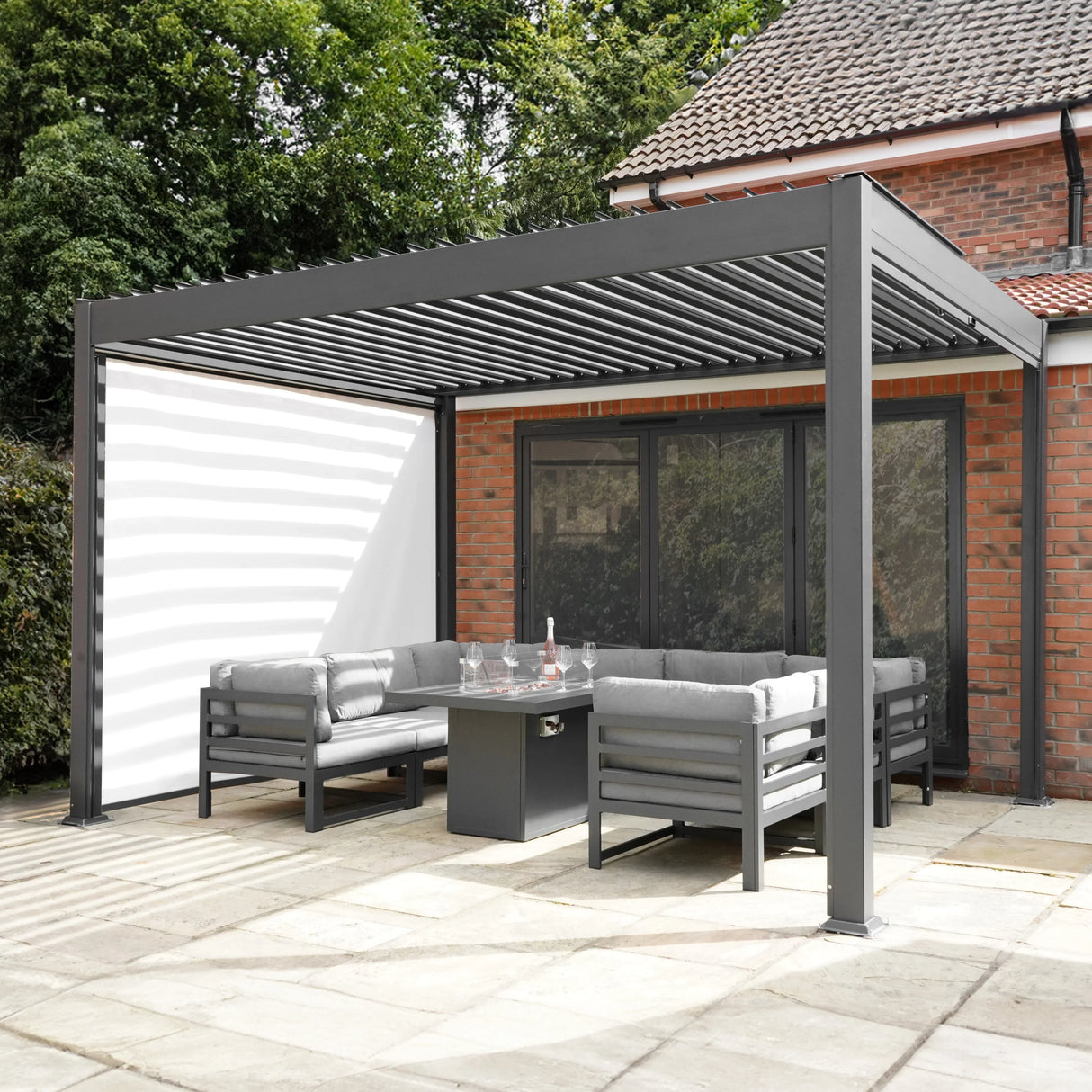 Anthracite aluminium pergola with white blinds, featuring a modern design and spacious seating area, perfect for outdoor relaxation
