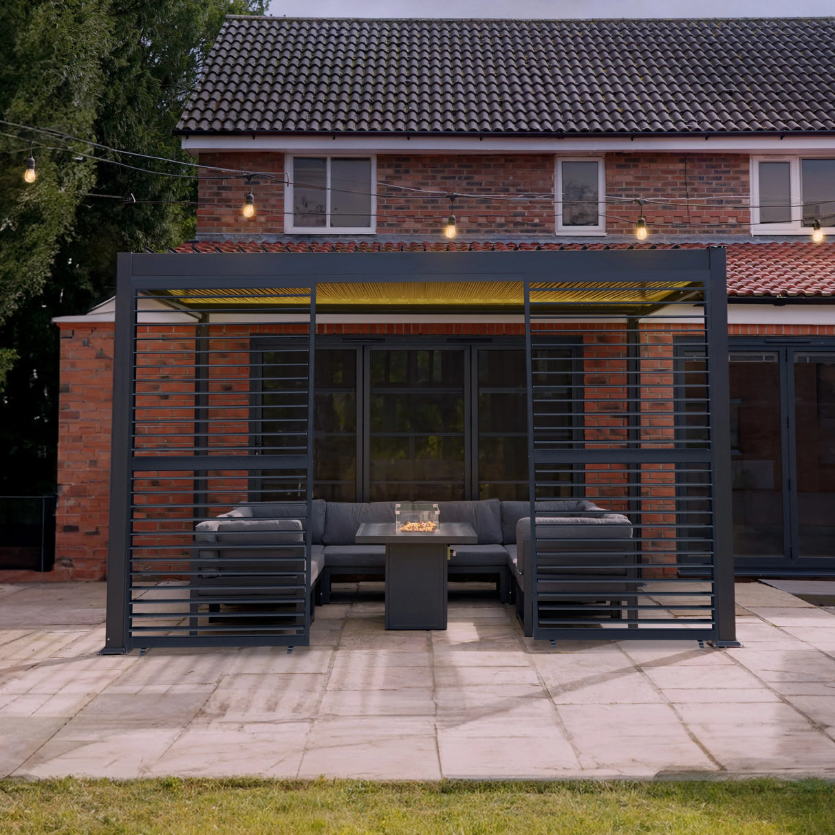 Anthracite aluminium pergola with LED lights, featuring two shutter panels, providing a modern outdoor seating area with a cozy ambiance