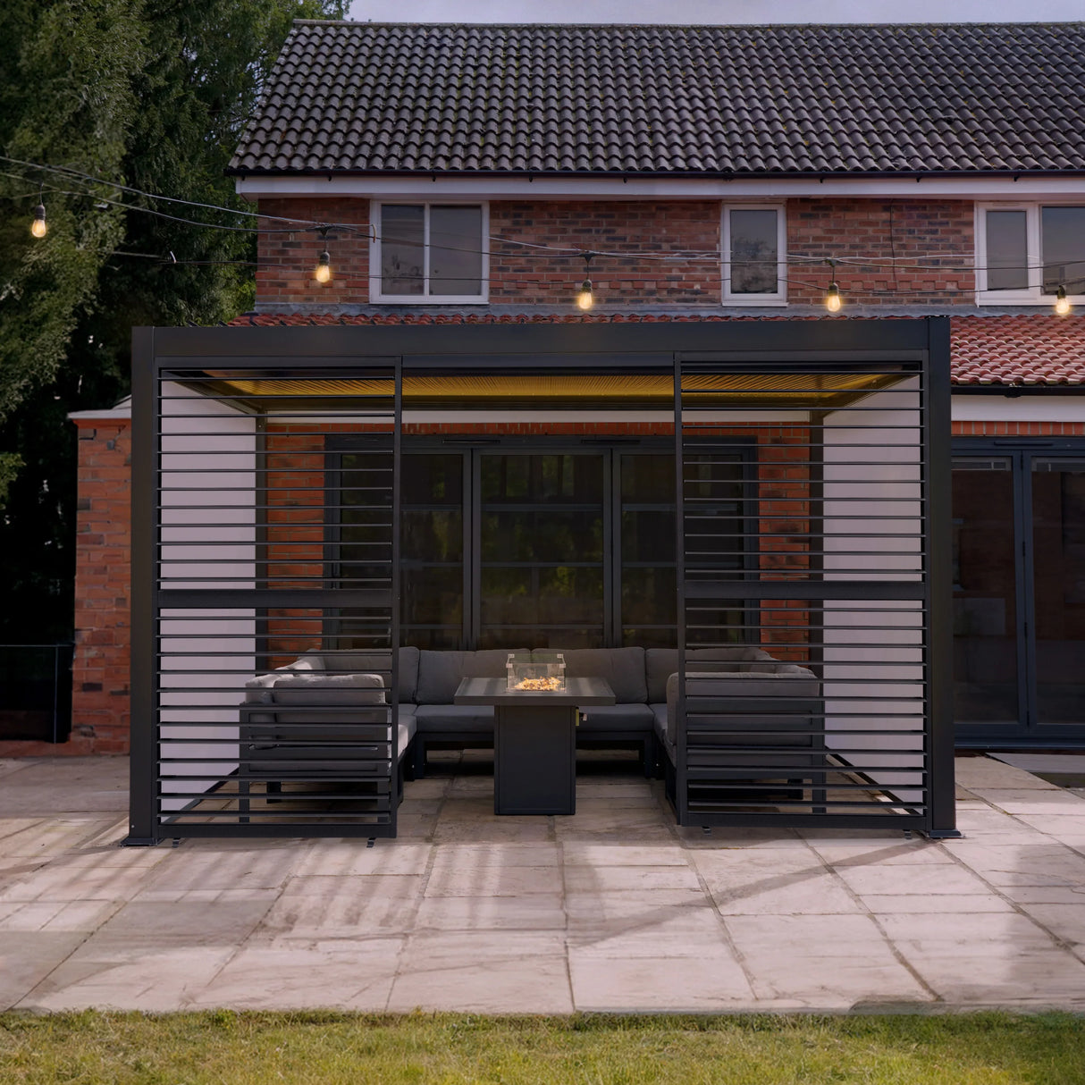 Anthracite aluminium pergola with white blinds, two side panels, LED lights, and modern outdoor seating area in a garden setting