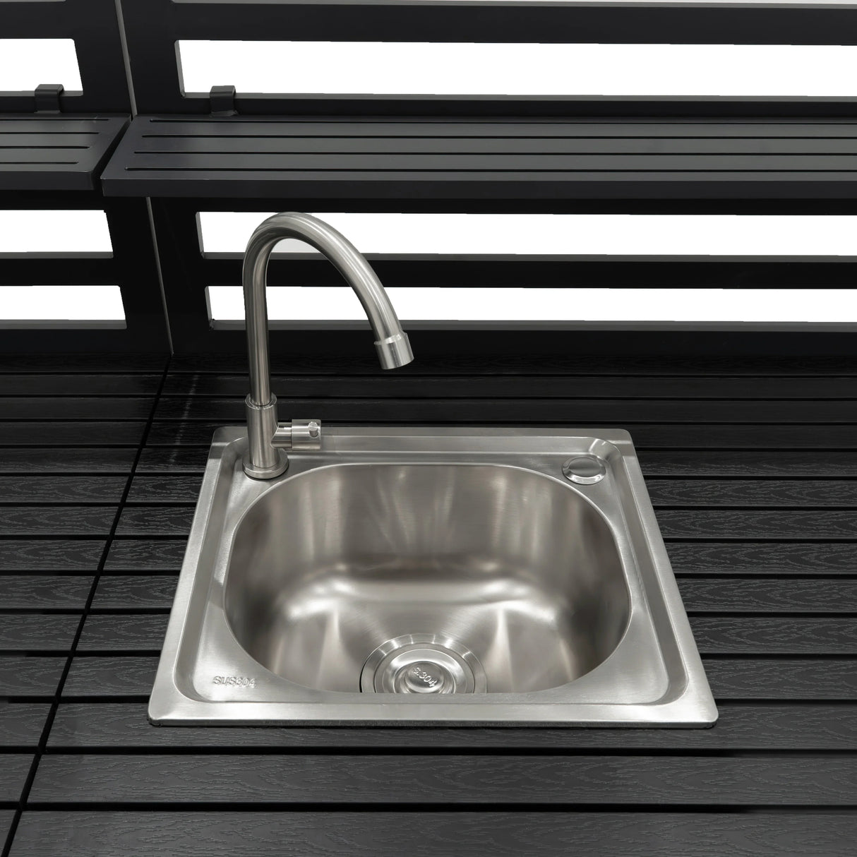Sleek stainless steel sink with a modern faucet, set on a dark wooden countertop, ideal for outdoor kitchen setups