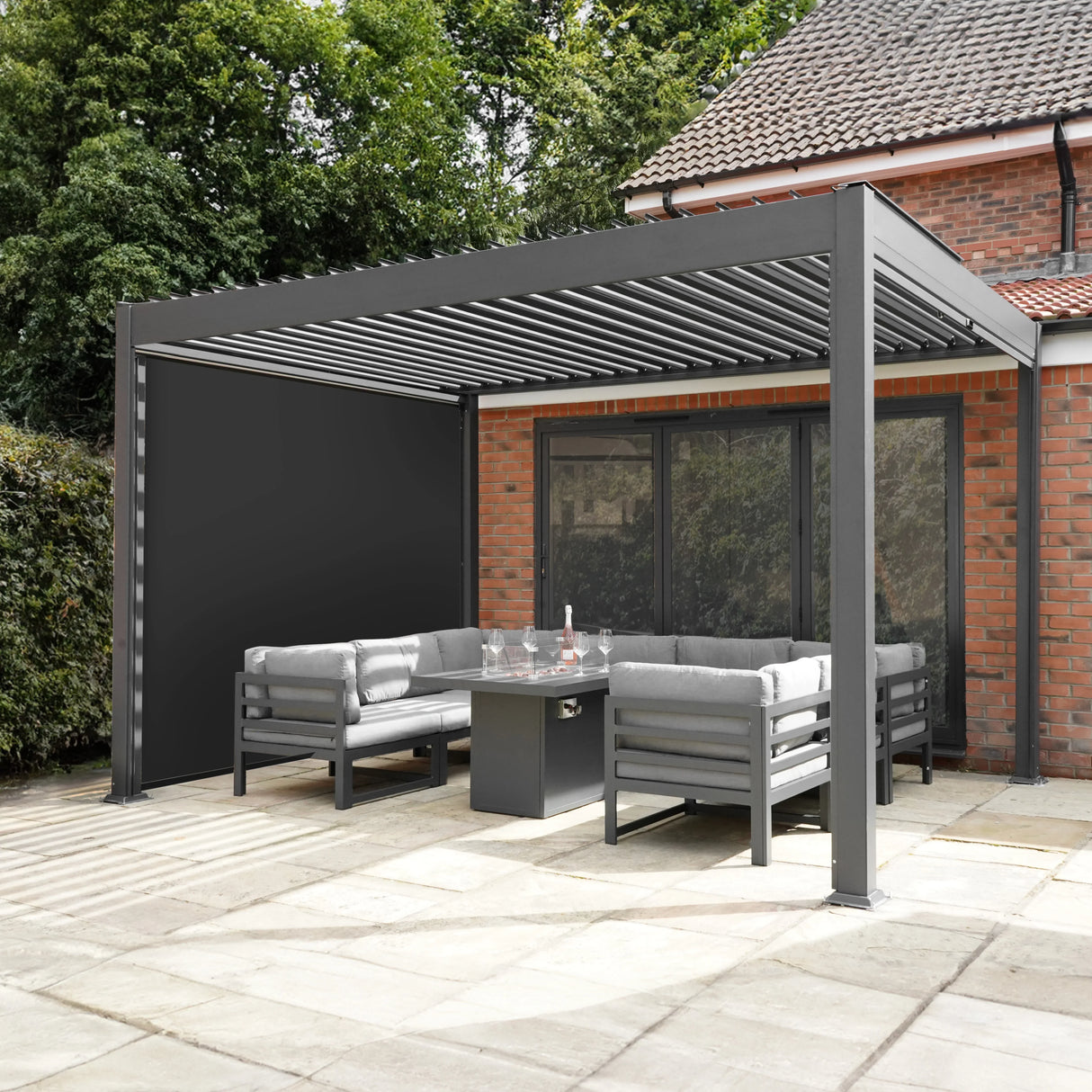 Aluminium pergola with anthracite blinds, 3m x 4m, featuring a sleek design, gray cushions, and a modern outdoor seating area