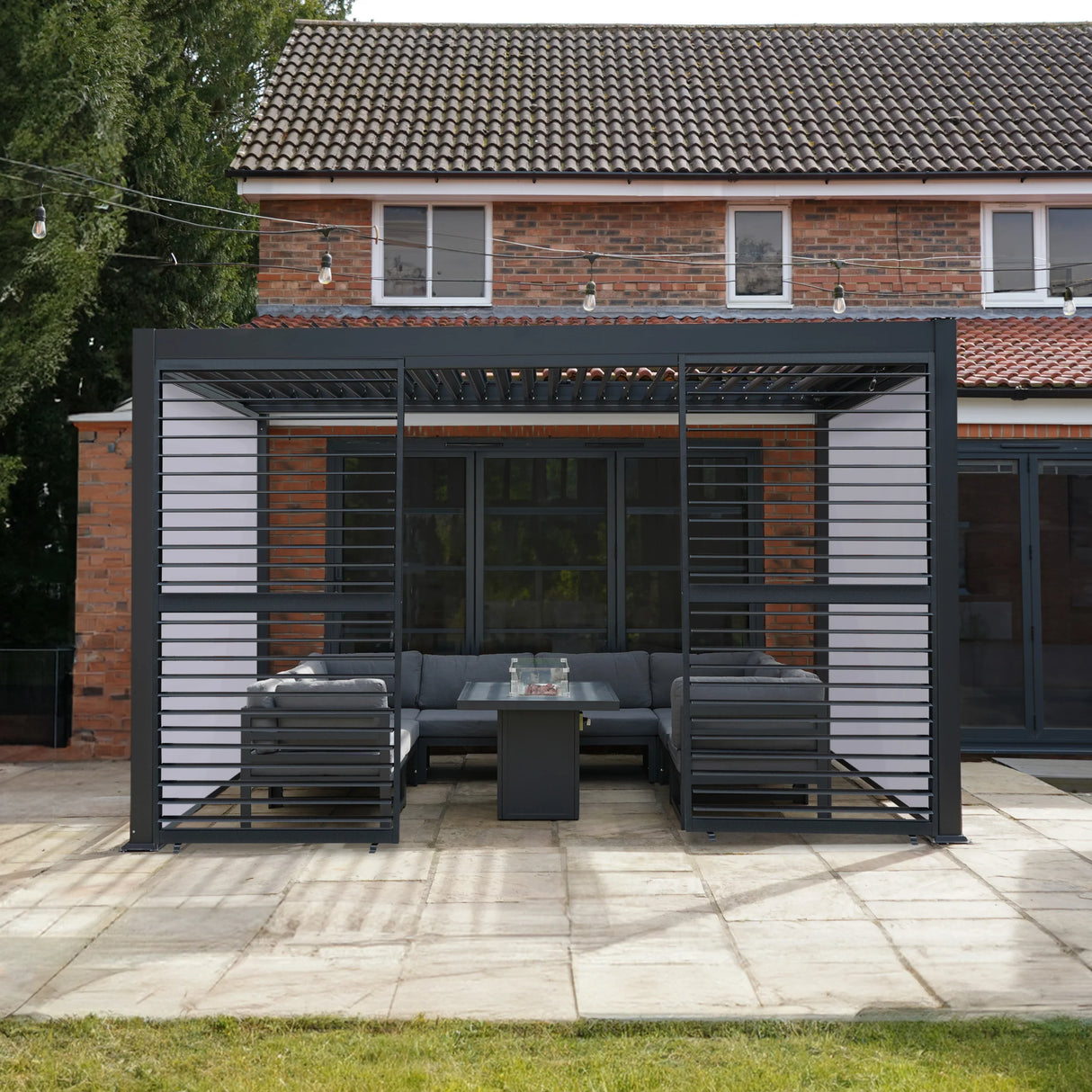 Anthracite aluminium pergola with white blinds and two shutter panels, featuring a modern design and outdoor seating area