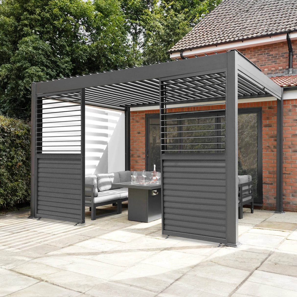 Anthracite aluminum pergola with white blinds and two shutter panels, featuring a modern design and outdoor seating area