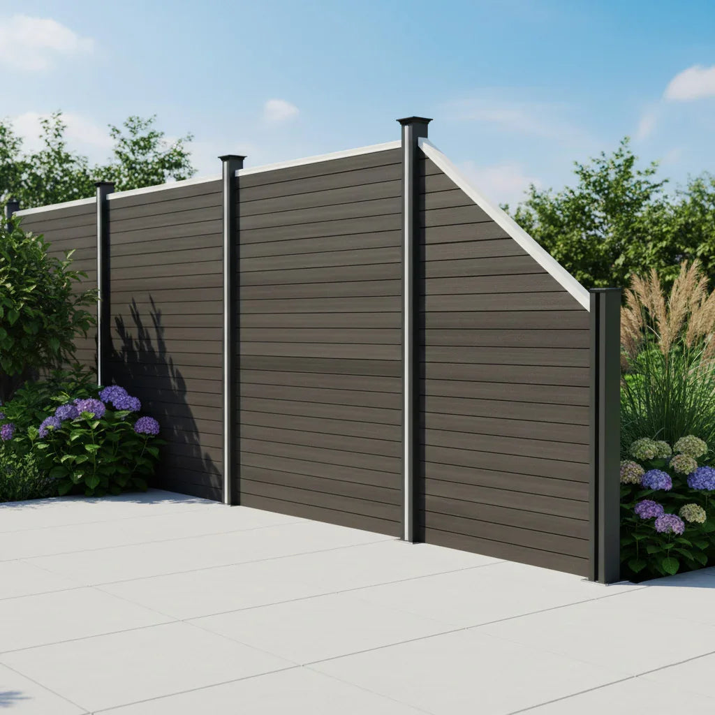 Composite angled fence panel in grey, featuring a sleek design with horizontal slats, complemented by black posts and vibrant greenery