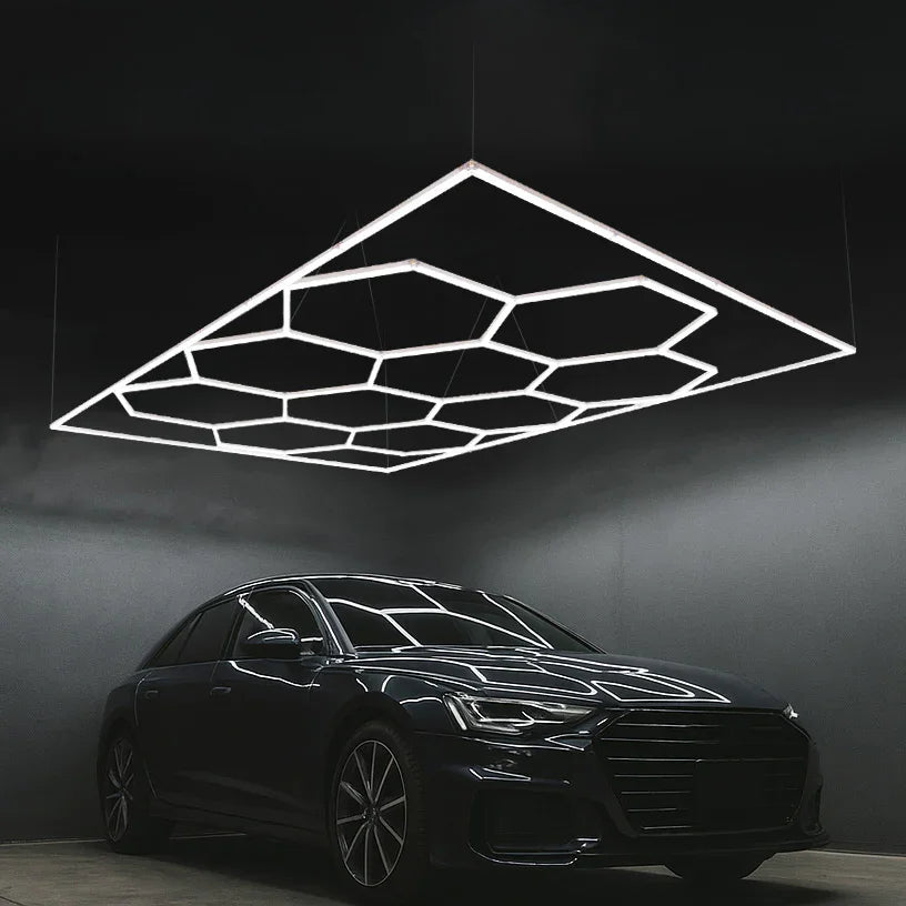 Hexagon LED lighting fixture with sleek white lines, suspended above a modern black car in a dark setting, creating a stylish ambiance