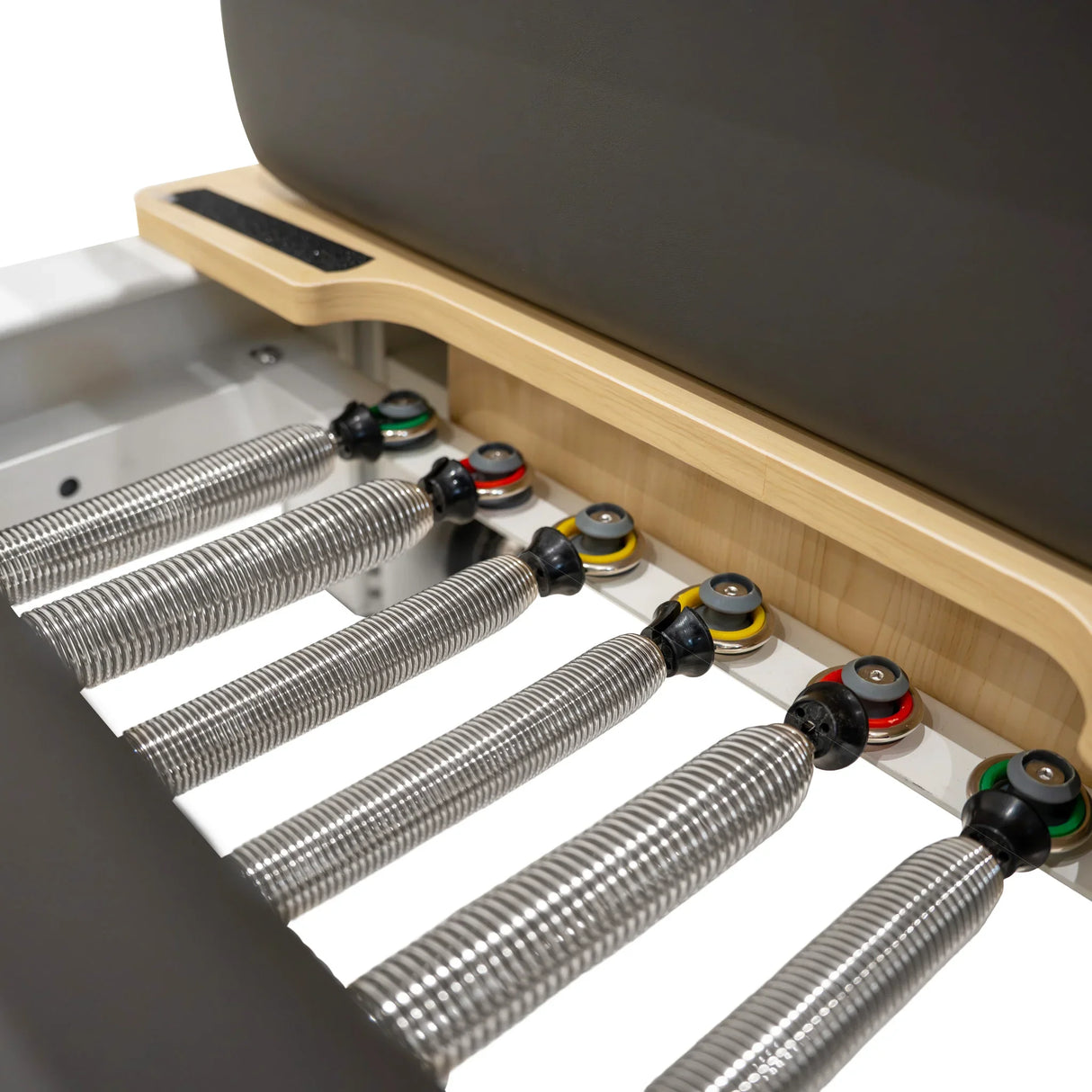 Aluminium Pilates reformer machine featuring a sleek design, wooden platform, and adjustable resistance springs in vibrant colors