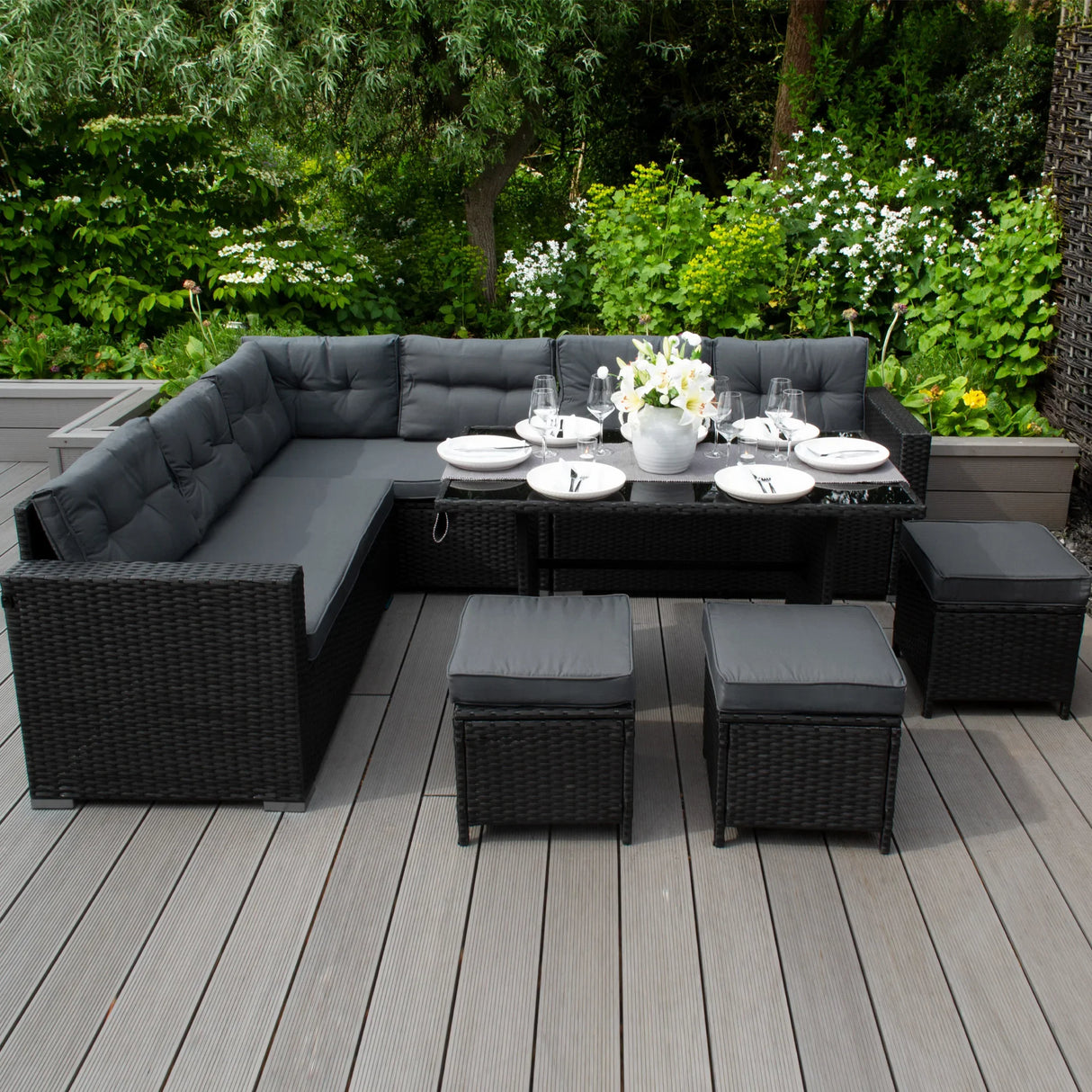Rattan corner set with plush gray cushions, featuring a sleek design, glass table, and matching ottomans, perfect for outdoor lounging