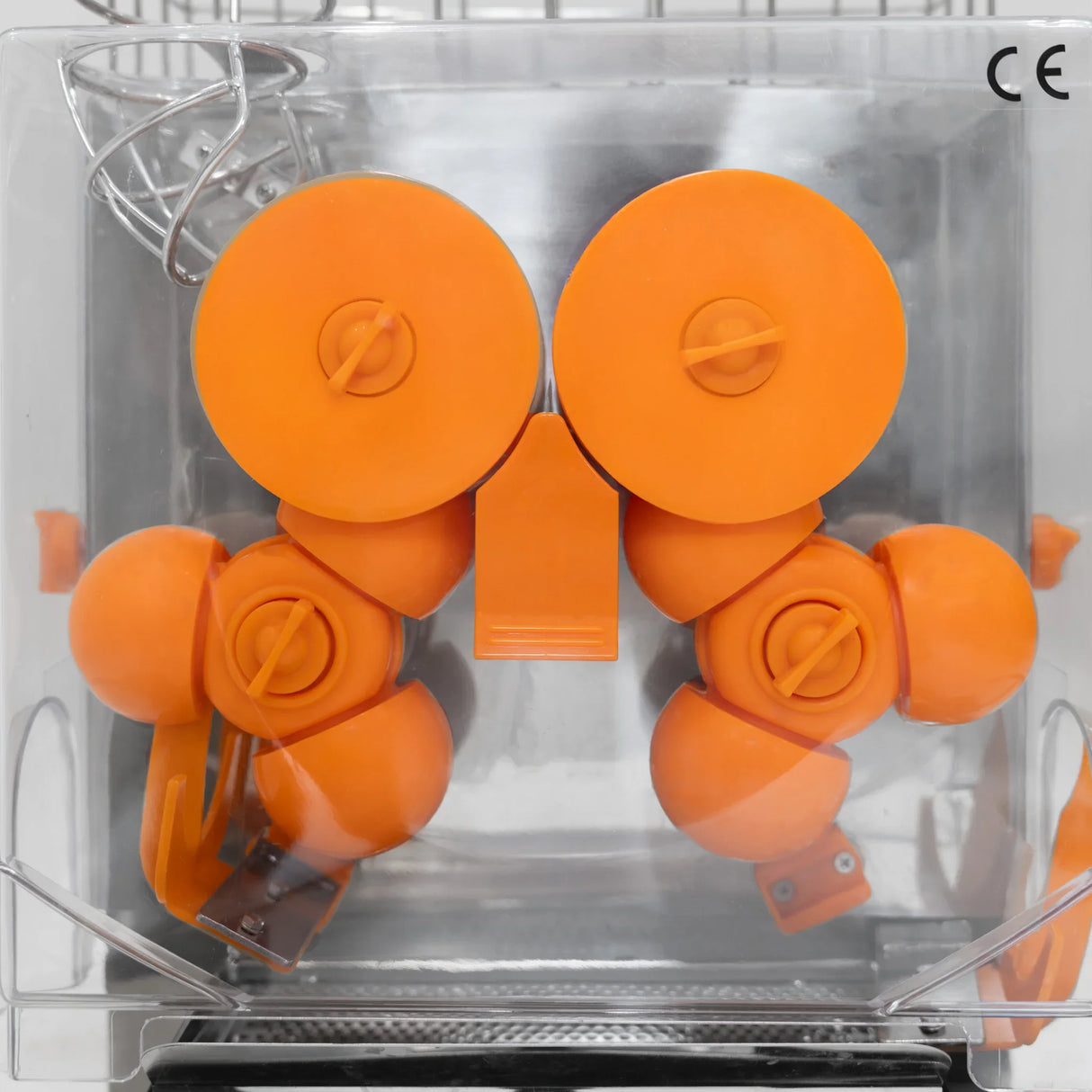 Commercial fruit juicer featuring vibrant orange components, including rotating juicing wheels and a durable design for efficient extraction