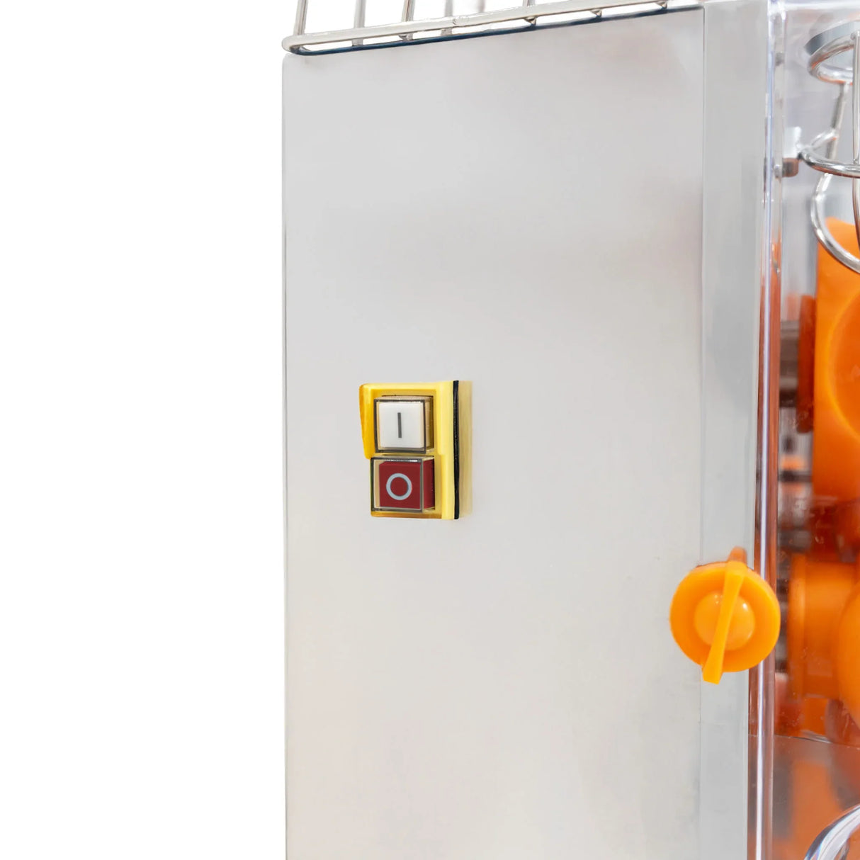 Close-up of a commercial fruit juicer's control panel featuring a gold power button and orange juice dispenser knob, showcasing stainless steel finish