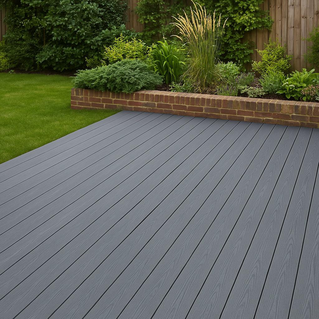 Grey composite decking boards arranged neatly in a spacious garden, showcasing a smooth texture and durable finish against lush greenery