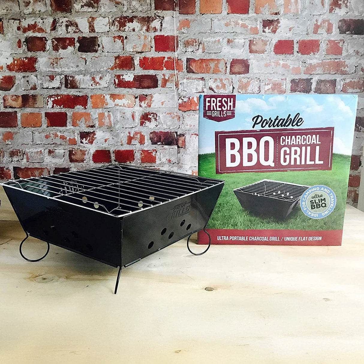 Portable BBQ grill with a sleek black finish, featuring a compact design and adjustable grates, alongside applewood wood chips packaging