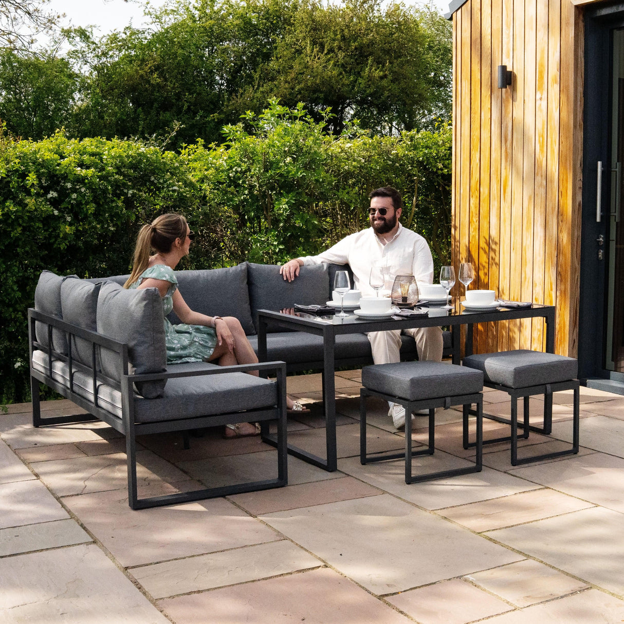 Anthracite grey aluminium corner sofa set with plush cushions, accompanied by a table, perfect for outdoor dining and relaxation