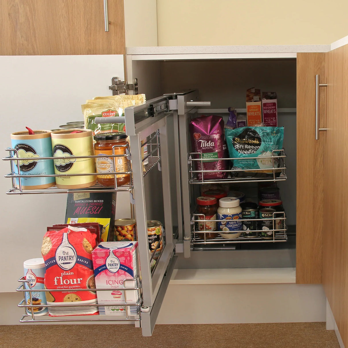 KuKoo Magic Corner Pull Out Kitchen Cupboard Drawers in silver, showcasing organized food items and jars in a modern kitchen setting