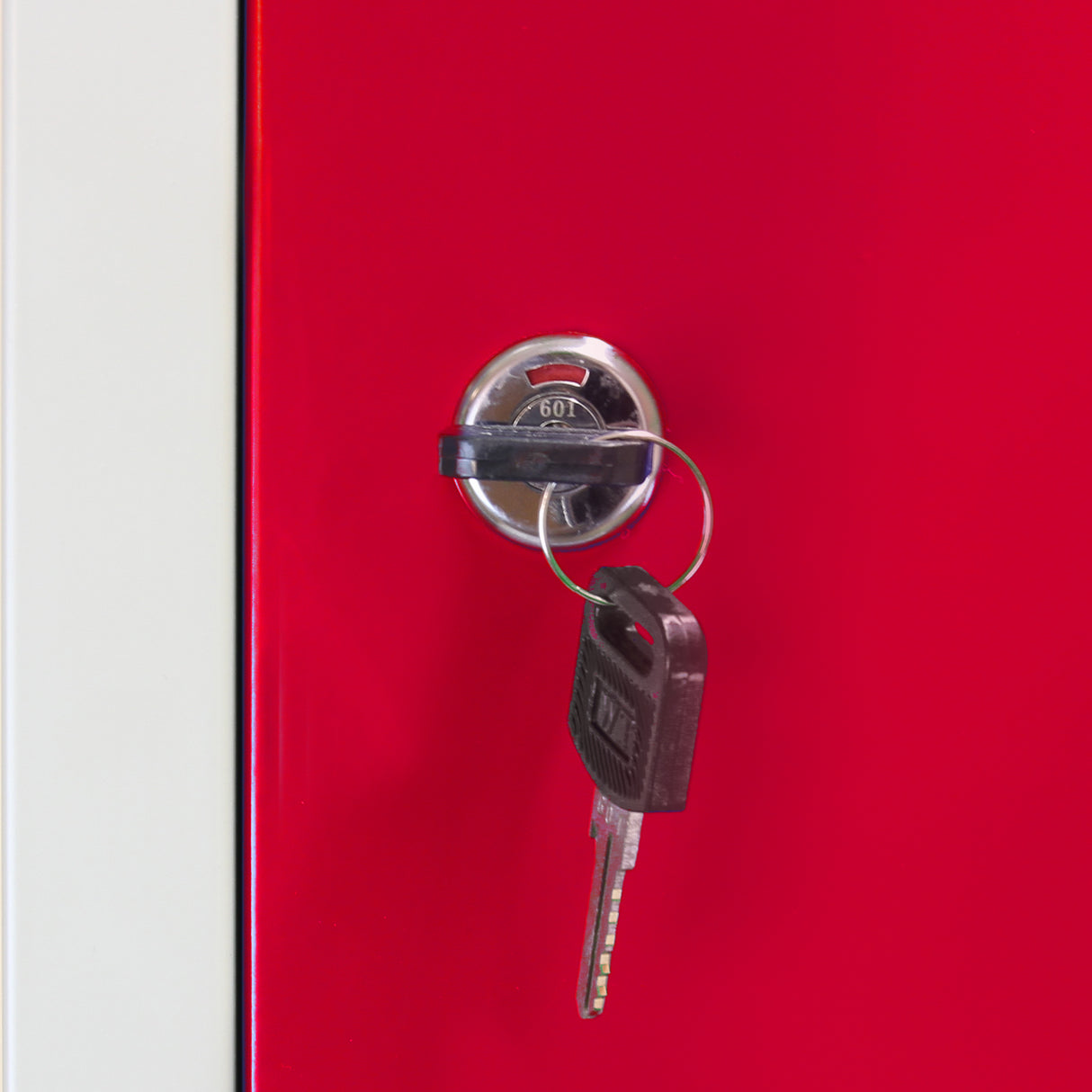 Red metal storage locker door with a shiny silver keyhole and a black key attached, showcasing a sleek, modern design