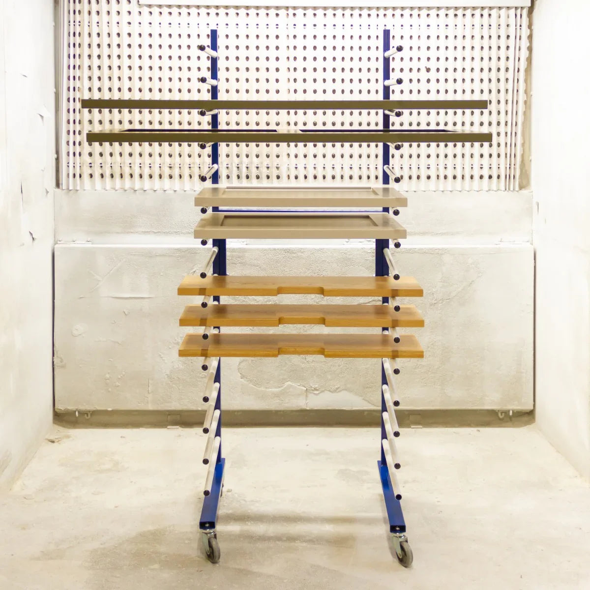 Monster Racking Spray Drying Rack Trolley with multiple shelves, sturdy blue frame, and smooth wooden surfaces, ideal for drying items
