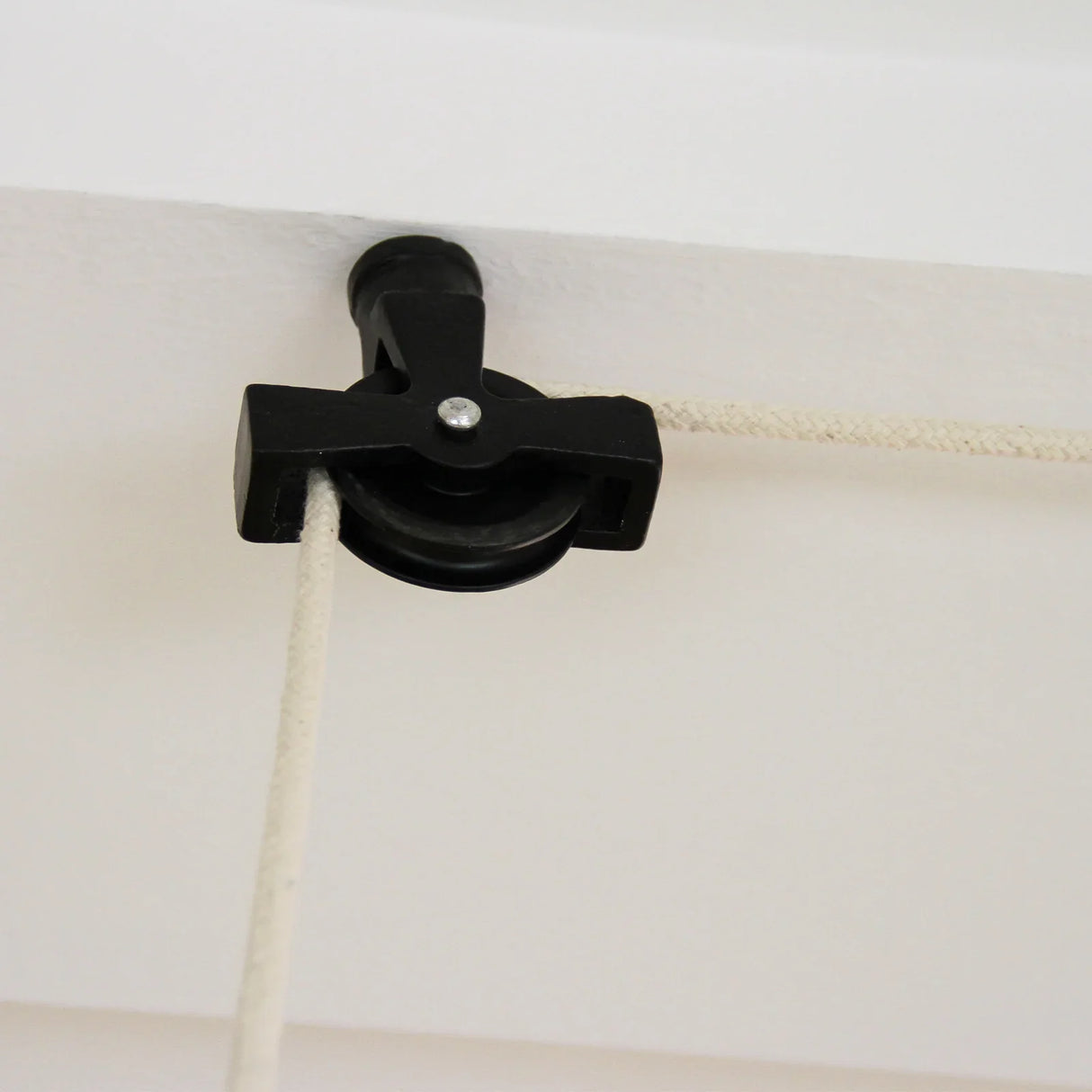 Black ceiling pulley for clothing airer, featuring a sturdy design with a smooth wheel and durable rope for efficient drying