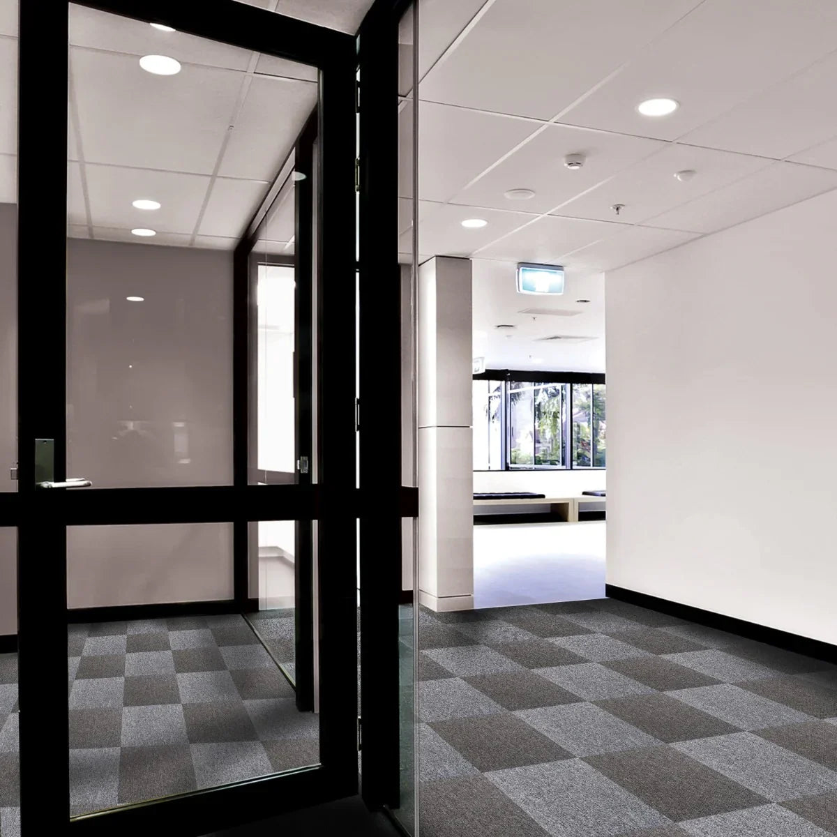 Anthracite carpet tiles arranged in a modern hallway, showcasing a textured pattern with varying shades of gray and a sleek finish