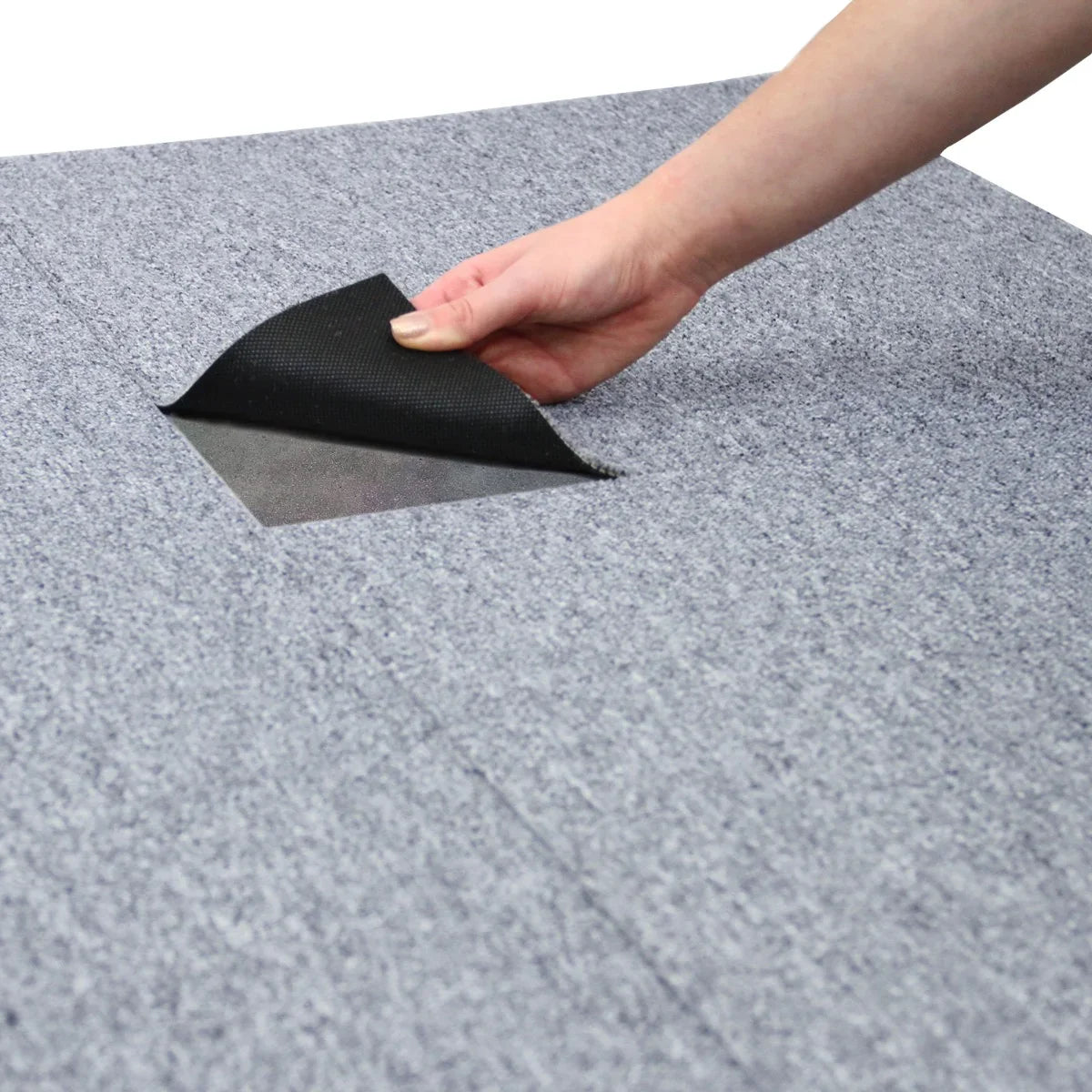 Platinum grey carpet tile being lifted to reveal its textured surface, showcasing durability and easy installation for versatile flooring solutions