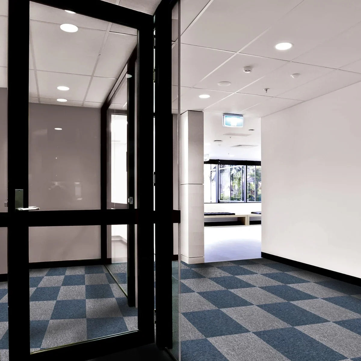 Storm Blue carpet tiles arranged in a modern hallway, featuring a textured pattern and a mix of dark and light blue squares