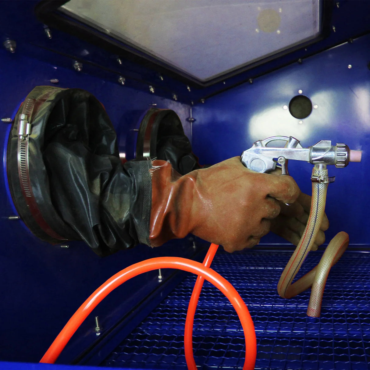 MAXBLAST Sandblasting Cabinet 220L featuring a gloved hand operating a sandblasting gun with a flexible hose in a blue interior