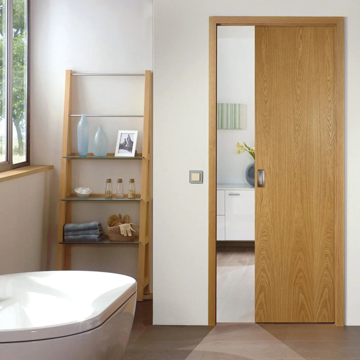 Hideaway Single Pocket Door Kit featuring a sleek wooden door in a modern bathroom setting with a stylish shelf and bathtub