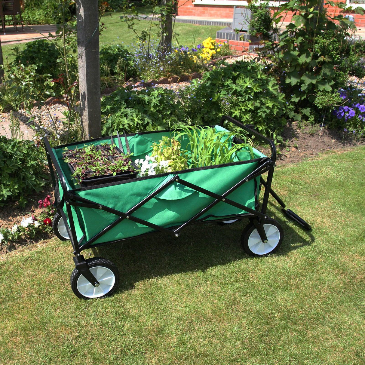 Foldable garden cart in vibrant green with a sturdy black frame, filled with plants, set on lush grass in a colorful garden