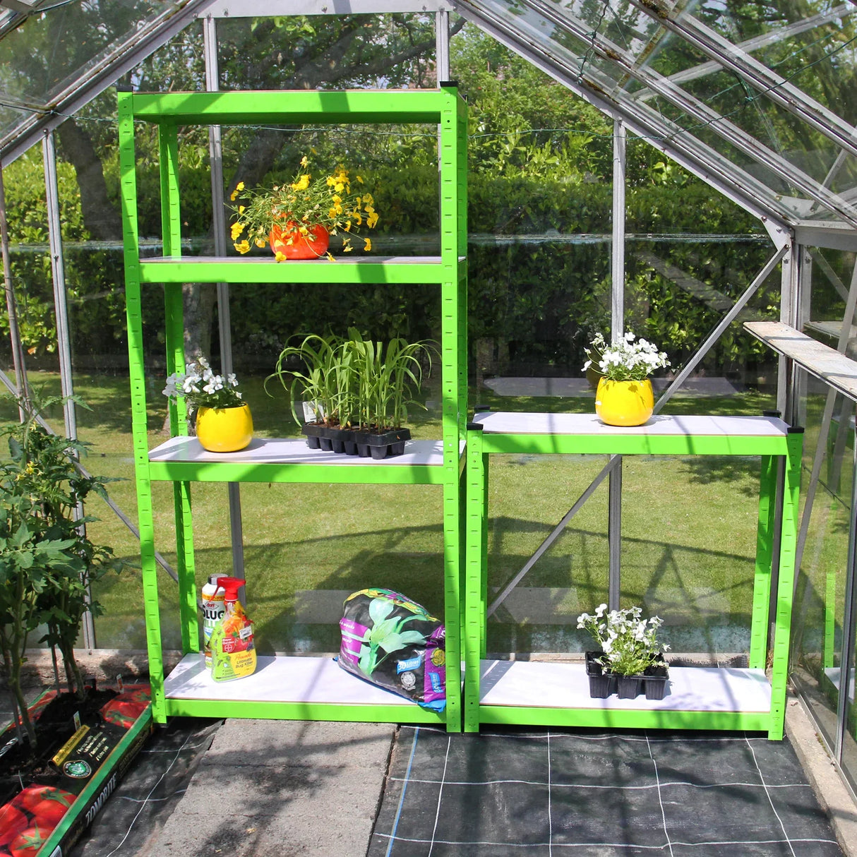 Greenhouse water-resistant racking in bright green, featuring multiple shelves with potted plants and gardening supplies displayed
