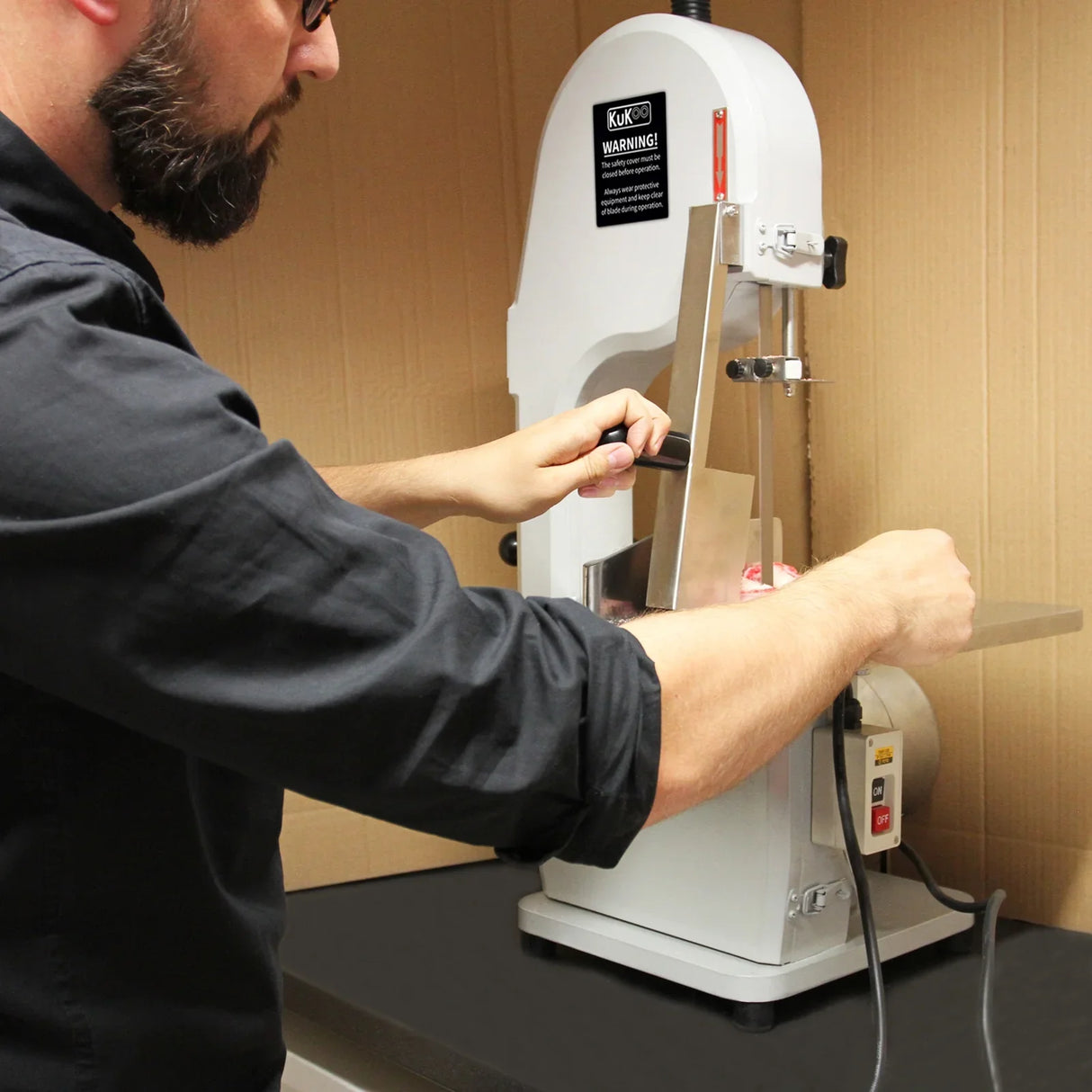 Kukoo Commercial Bone Saw Bandsaw in use, featuring a stainless steel blade, sturdy base, and safety guard for precision cutting