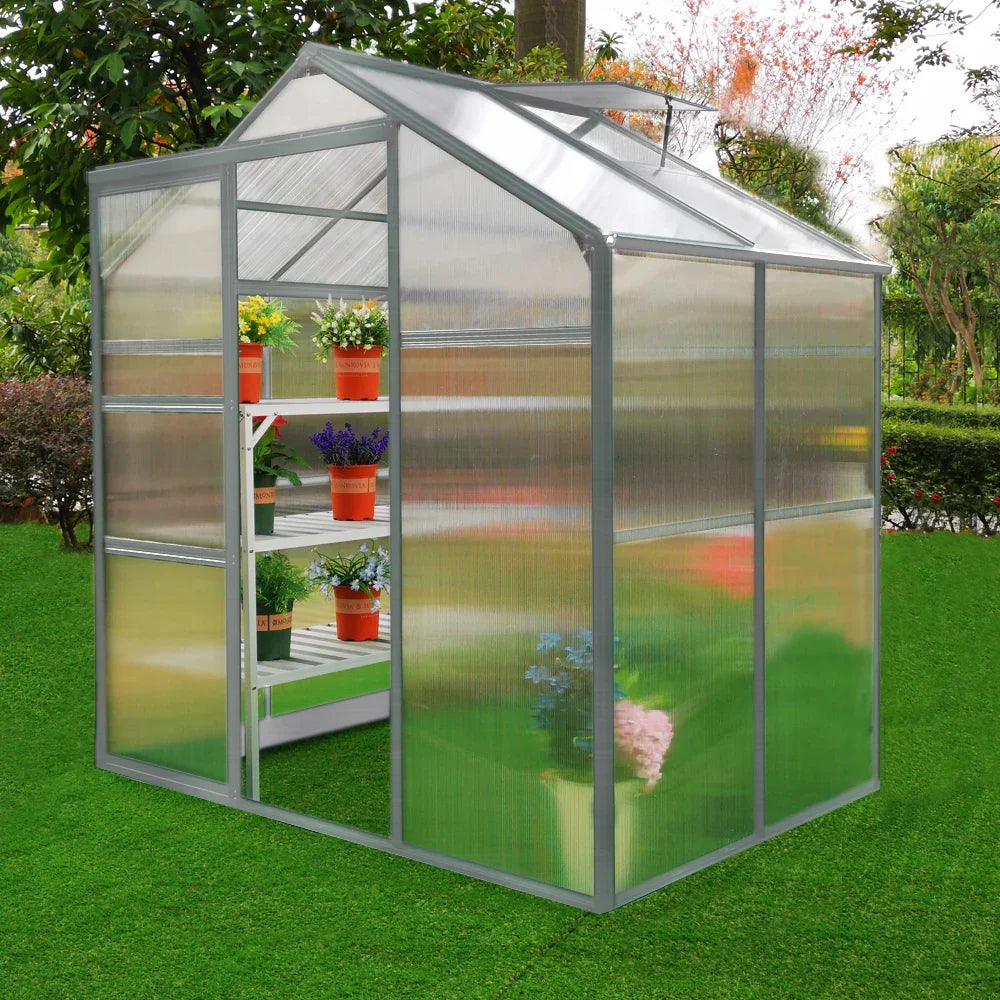 Greenhouse 6ft x 4ft with clear polycarbonate panels, metal frame, and potted plants on shelves, set on green grass