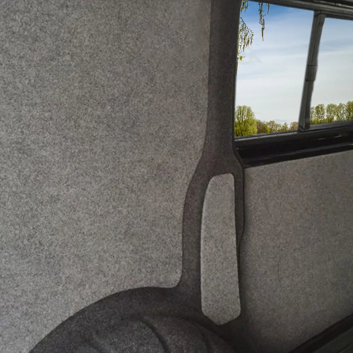 Anthracite van lining with smooth texture, featuring a sleek design and a view of greenery through the window