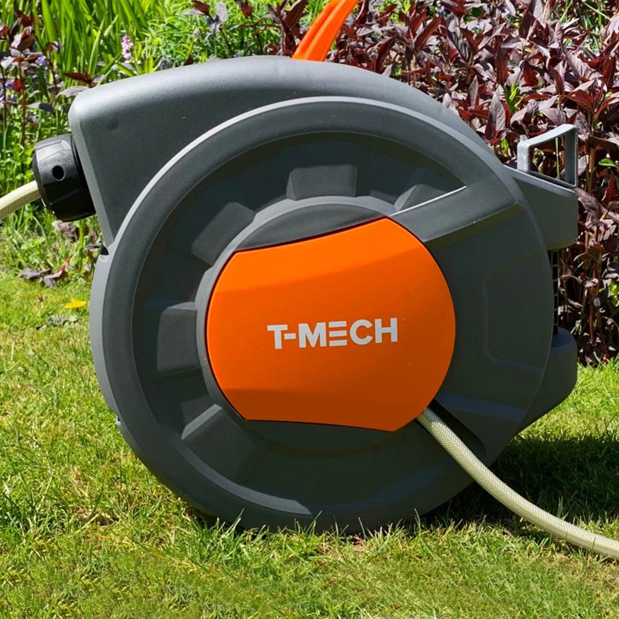 20m retractable hosepipe with a durable grey casing and vibrant orange accents, set against a lush green garden backdrop