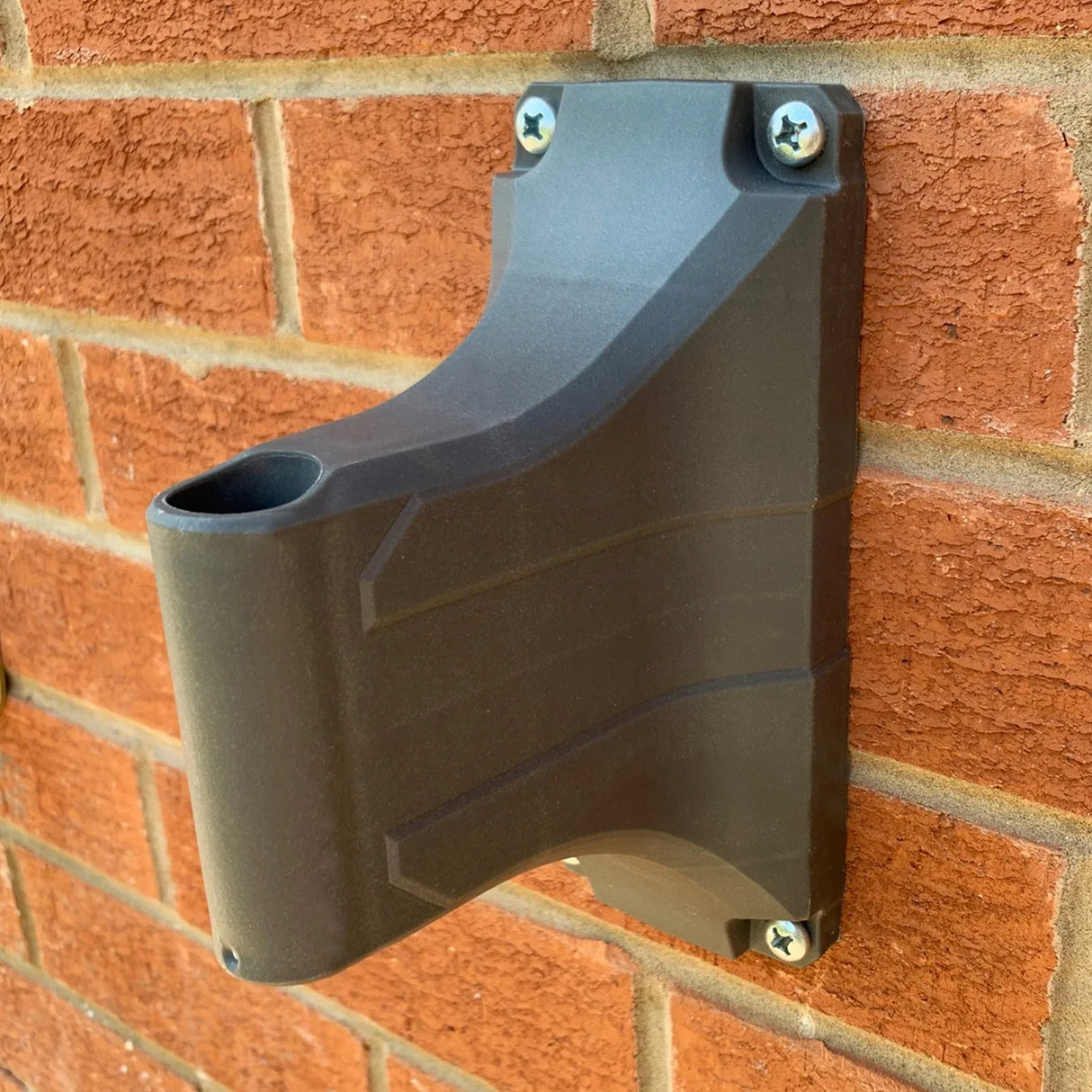 30m retractable hosepipe wall mount in durable black plastic, securely attached to a brick wall, featuring a sleek, modern design